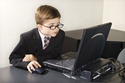 мальчик в очках сидит перед ноутбуком