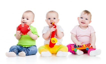 Трое маленьких детей играют на музыкальных инструментах