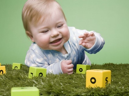 ребенок играет на ковре с кубиками