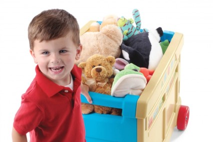 мальчик катит контейнер с игрушками