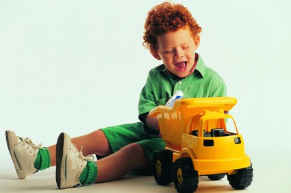 мальчик играет с грузовой машинкой