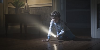 Мальчик с фонариком в темноте