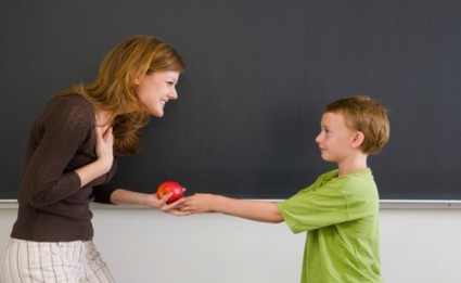 Мальчик делится яблоком с учителем
