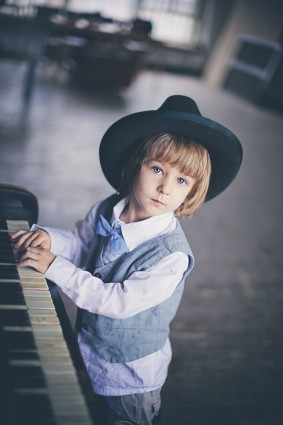 Мальчик в шляпе за фортепиано