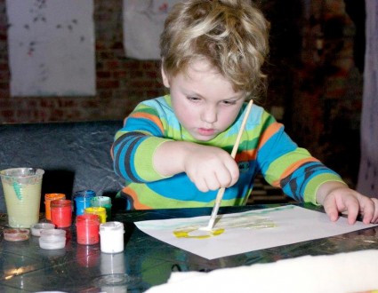 Мальчик рисует красками