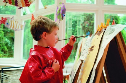 Мальчик в красной накидке рисует