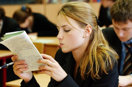 Девочка читает по тетради