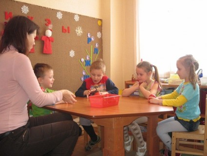 Дети и воспитательница сидят за столом