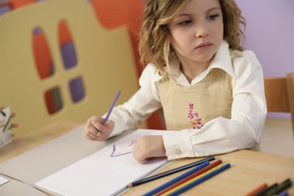 Девочка рисует карандашами