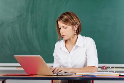Учитель с бумагами и ноутбуком