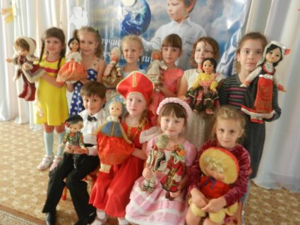 Дети в элементах национального костюма держат кукол в народных костюмах