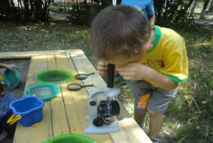 Ребёнок смотрит в микроскоп
