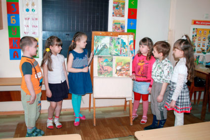 Дети стоят у доски и рассматривают изображения животных