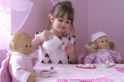 девочка угощает кукол